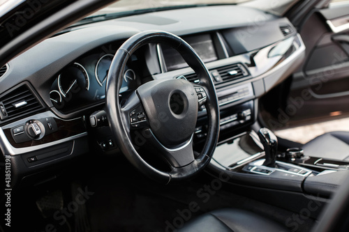Luxury modern car Interior. Steering wheel, black leather seats, shift lever and dashboard. Detail of modern car interior.