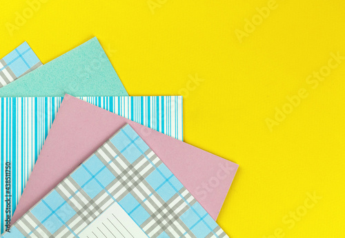 School exercise books on bright yellow desktop, elemntary school concept background with copy space photo