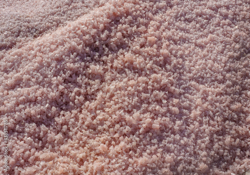 Big cristals of pink sea salt, oudoors photo. Abstract background of salt grains.