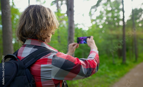 Man doing selfie with smartphone in the forest.