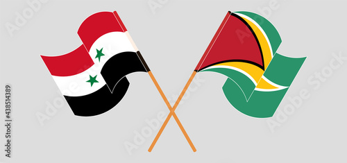 Crossed and waving flags of Syria and Guyana
