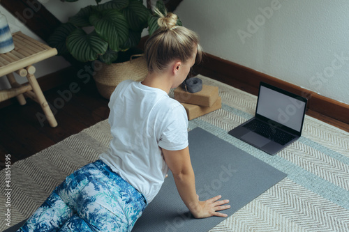 Weiße Frau macht online Yoga zuhause photo