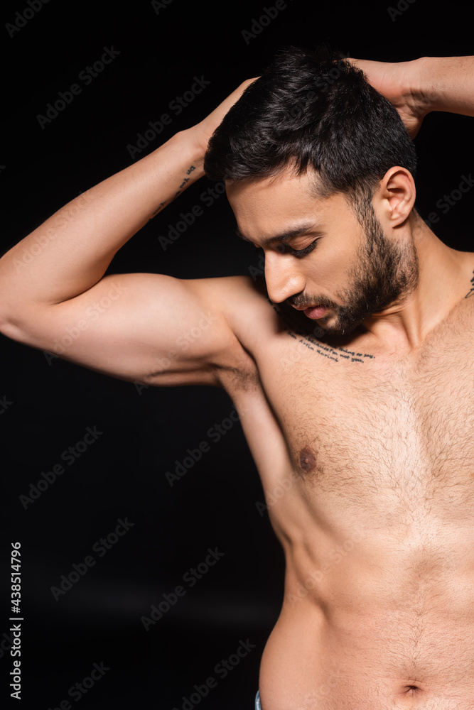 Bearded man looking at shirtless torso isolated on black Bearded man looking at shirtless torso isolated on black