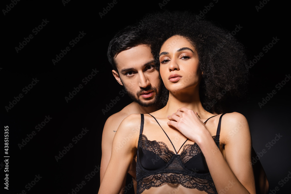 Sexy interracial couple looking at camera isolated on black Sexy interracial couple looking at camera isolated on black