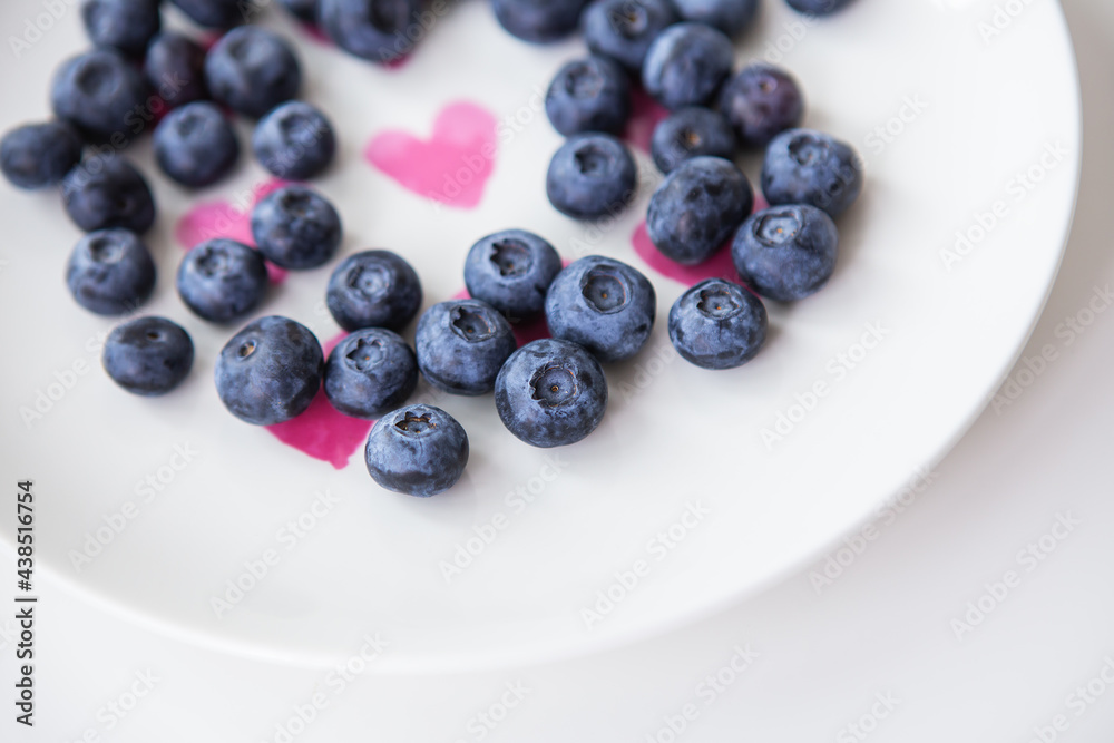 Delicious blueberries lie on a plate with a heart inside. Delicious and healthy food. Delicious blueberries lie on a plate with a heart inside. Delicious and healthy food.