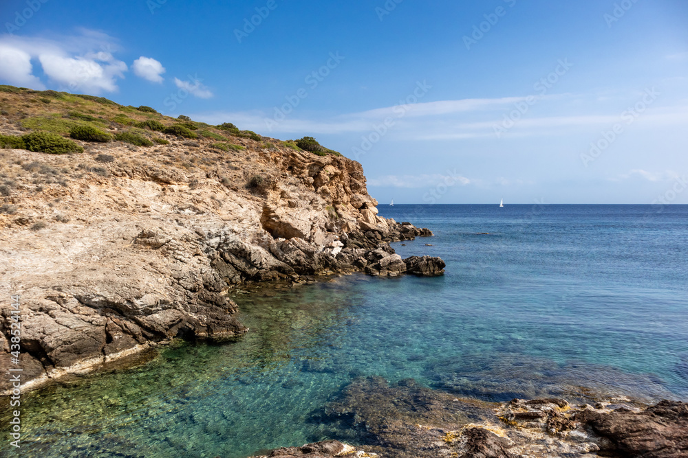 Wild mediterranean sea with rocky cliffs shore and blue clear water. Travel Greece near Athens. Summer nature scenic shore