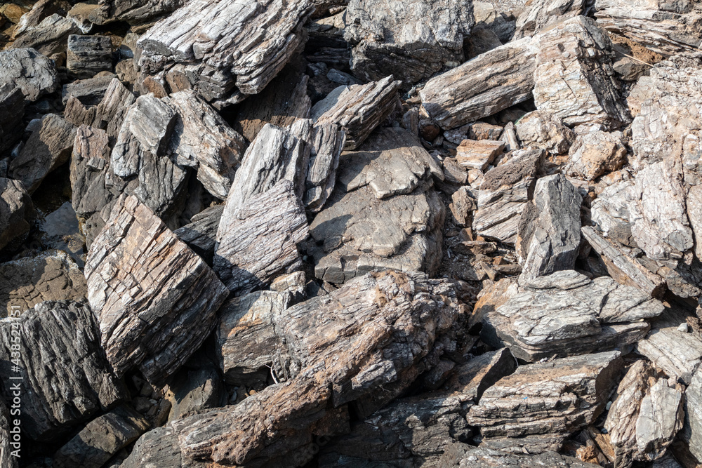 Aegean sea sharp big rocks shore close-up texture. Various rocky surface in sunny Greece near Athens Aegean sea sharp big rocks shore close-up texture. Various rocky surface in sunny Greece near Athens