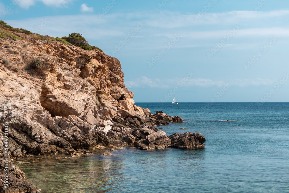 Wild mediterranean sea with rocky cliffs shore and blue clear water. Travel Greece near Athens. Summer nature scenic color graded view