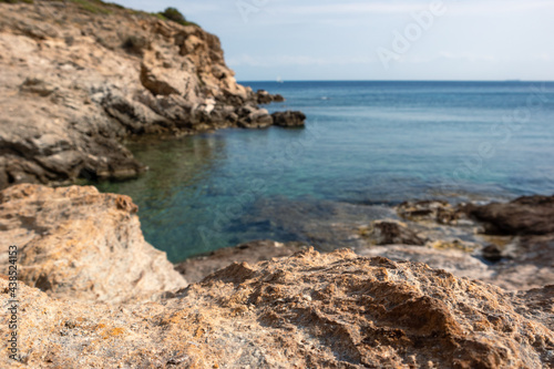 Wild mediterranean sea with rocky cliffs shore close-up and blue clear water. Travel Greece near Athens. Summer nature scenic lagoon