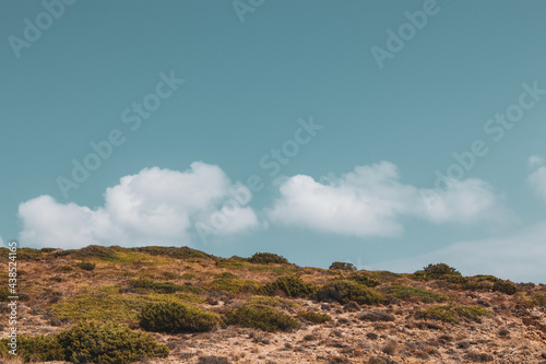 Steppe Greece terrain landscape with scenic cloudscape on vivid sky. Natural south Europe rocky bushy view. Color graded