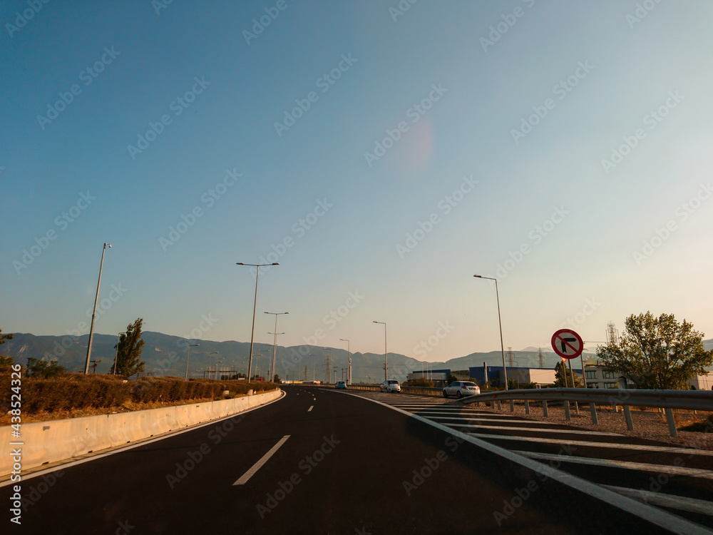 Driving autobahn asphalt road in Greece, Europe. Trip from Thessaloniki to Athens. Sunset sunny clear mountains view in automobile journey