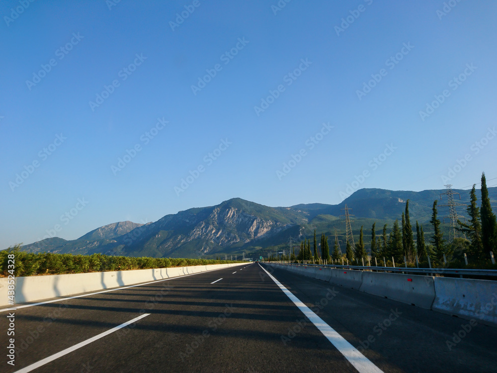 Naklejka premium Driving autobahn asphalt road in Greece, Europe. Trip from Thessaloniki to Athens. Sunset sunny clear mountains view in automobile journey