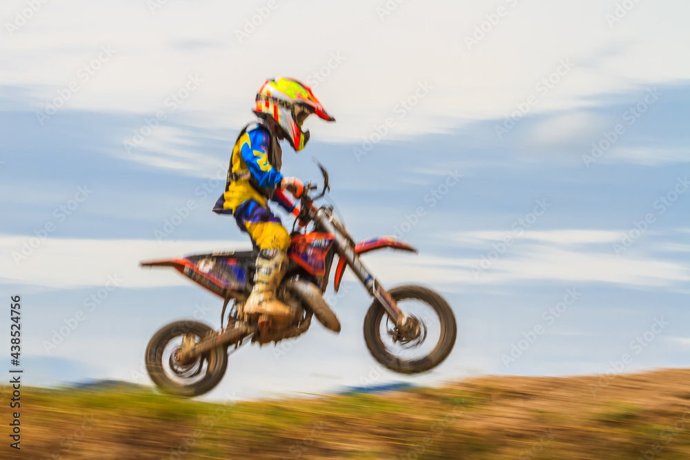 Motion blur of motocross rider in motocross competition Motion blur of motocross rider in motocross competition
