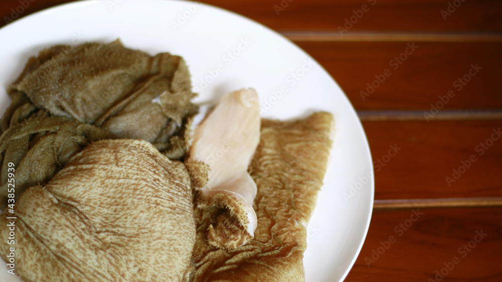 Beef tripe on white plate, wood background. Beef tripe on white plate, wood background.