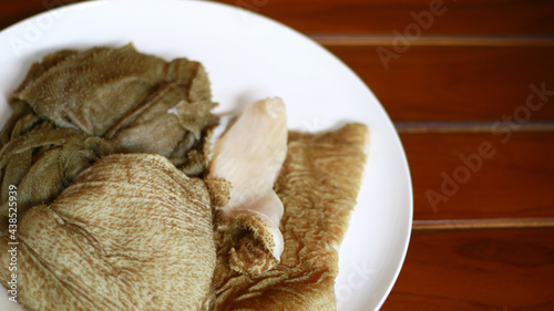 Beef tripe on white plate, wood background.  © Harismoyo