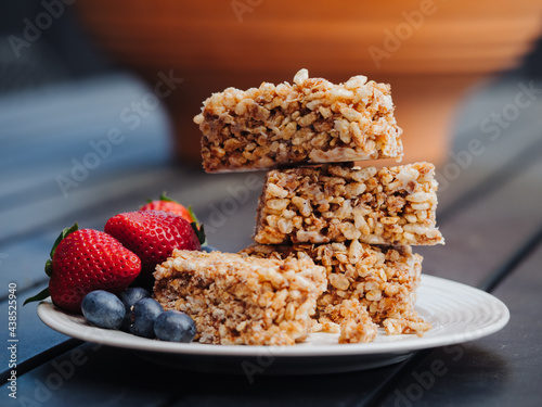 Stacked rice crispy bars on a plate with a side of berries