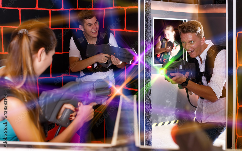 friends with plastic laser pistols in their hands playing laser tag (first-person view).