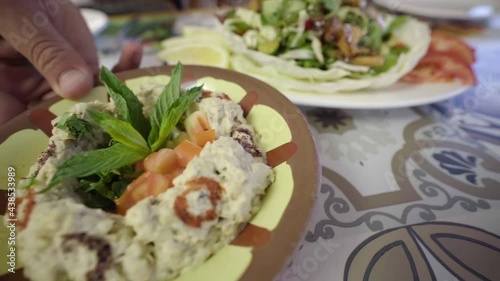 Serving dishes of Fattoush and baba ghanouj on a restaurant table photo