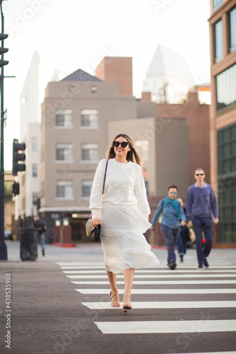 Adult woman crossing the street in the city.