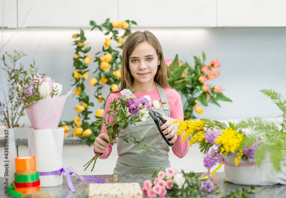 Young girl cutting flower with scissors  at flower shop. Hobby and leisure concept