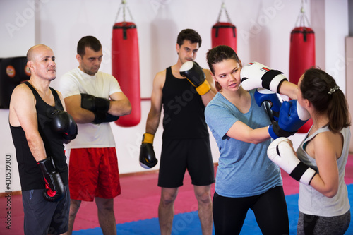 Two young athlete women practicing boxing sparring at sport class © JackF