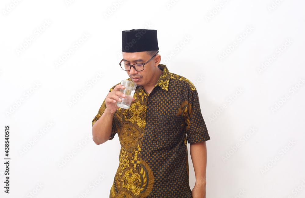 Asian Man Drinking Water While Standing Against White Background Asian Man Drinking Water While Standing Against White Background