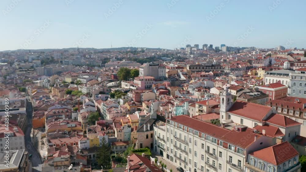 Panning aerial view of town in sunny day. Rooftop view from flying drone. Lisbon, capital of Portugal.