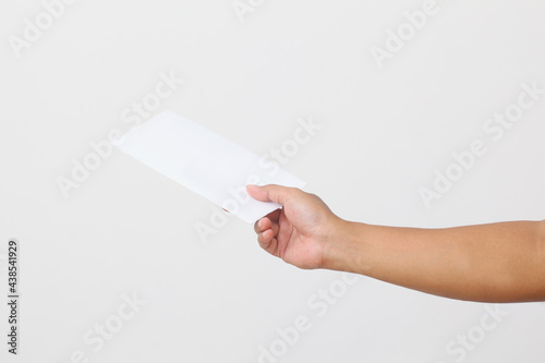 Man's hand holding envelope isolated on white background. Close up photo