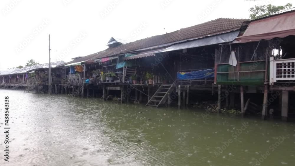 View of a deserted Amphawa Floating Market from a long-tailed river boat in the rain. No tourists and traders due to Covid 19 and travel restrictions.  