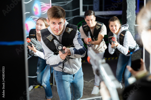 Excited guy laser tag player in bright beams. High quality photo