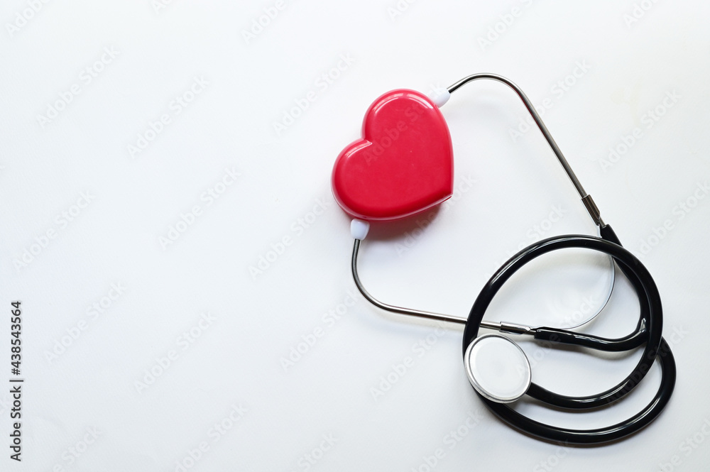 Top Views of Heart-shaped plastic box with Black Stethoscope isolated on blue background with copy space at Thailand. Medical device concept. Selective Focus. Top Views of Heart-shaped plastic box with Black Stethoscope isolated on blue background with copy space at Thailand. Medical device concept. Selective Focus.