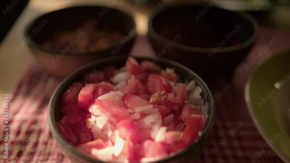 Black bowls of pico de gallo above checkered tablecloth Black bowls of pico de gallo above checkered tablecloth