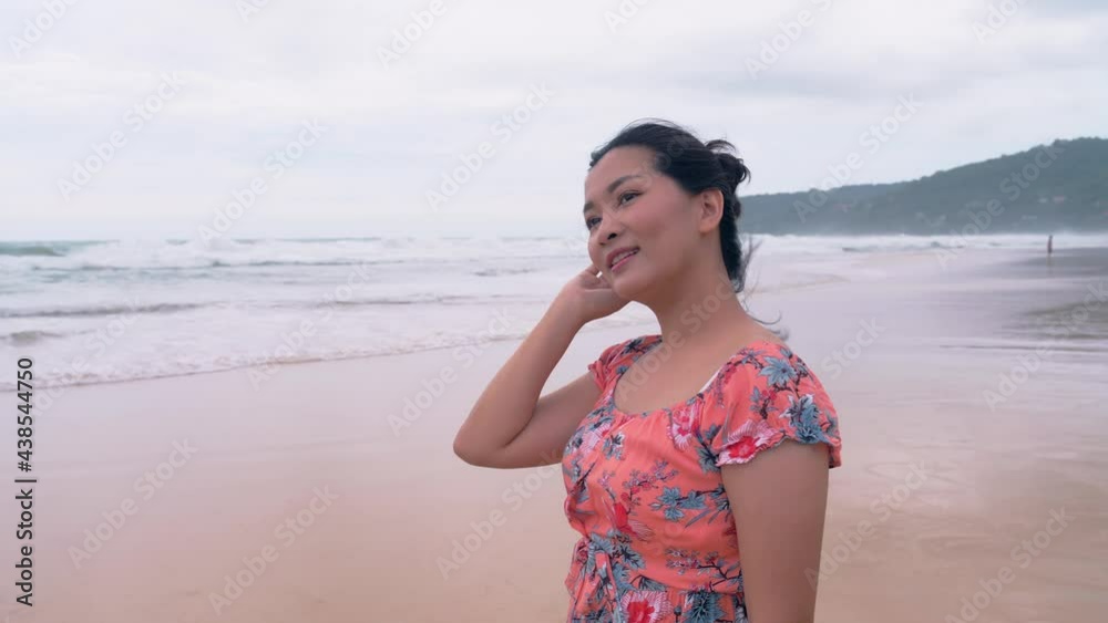 Beautiful Asian woman on vacation looking to the horizon at deserted beach. Beautiful Asian woman on vacation looking to the horizon at deserted beach.