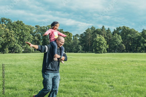 Father playing with his cute little daughter on the field. Concept of friendly family. Great family vacation.