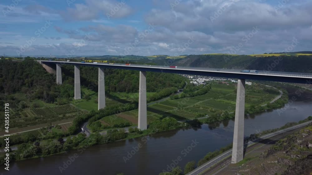 Aerial ascend shot showing new modern Bridge with driving cars over Moselle River between vineyards in Germany. Aerial ascend shot showing new modern Bridge with driving cars over Moselle River between vineyards in Germany.
