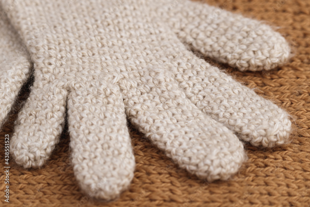 Close-up detail of part of cream-colored wool glove, crocheted. Winter clothing. Close-up detail of part of cream-colored wool glove, crocheted. Winter clothing.