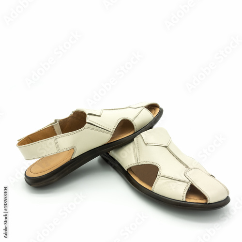 Men's summer open sandals made of genuine light beige leather. Flat sole. Close-up. Isolated on white background