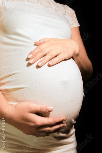 beautiful young pregnant woman on a black background