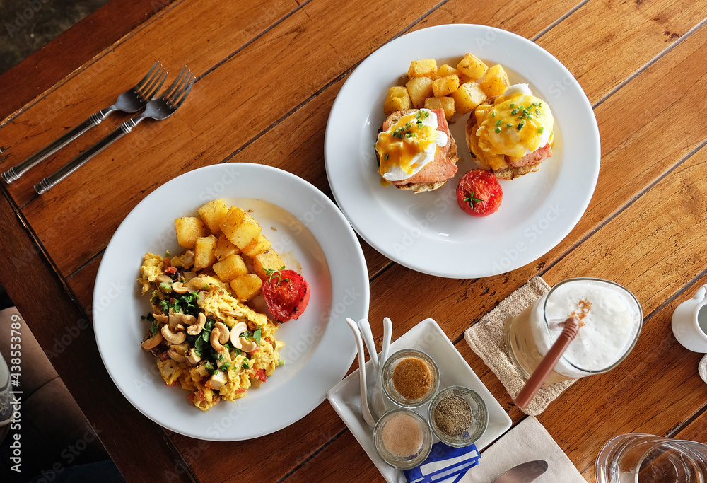 Scrambled and eggs benedict served with grilled potatoes and coffee