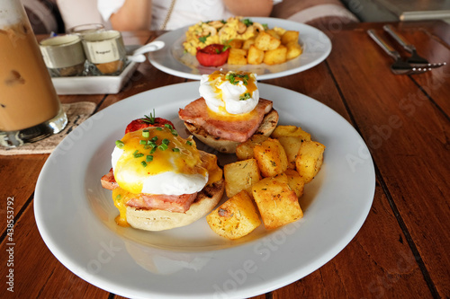 Scrambled and eggs benedict served with grilled potatoes and coffee