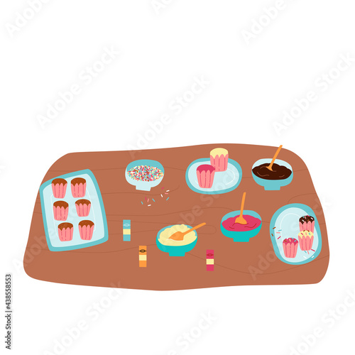 Baking process, kitchen wooden table, worktop with pastry, glazing decoration. Muffins wait for cream, sprinkles adding.