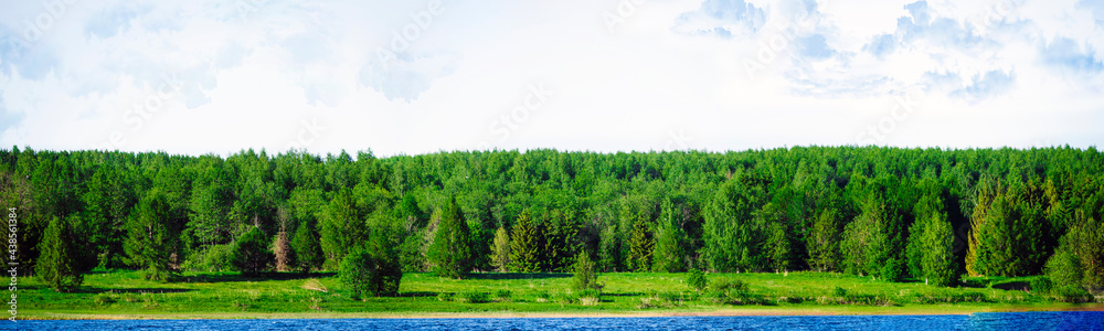 Landscape panoramic banner with a beautiful view of the bank of the blue Volga River with green forest and sky in Russia. Summertime landscape banner, panorama with copy space for text. Landscape panoramic banner with a beautiful view of the bank of the blue Volga River with green forest and sky in Russia. Summertime landscape banner, panorama with copy space for text.