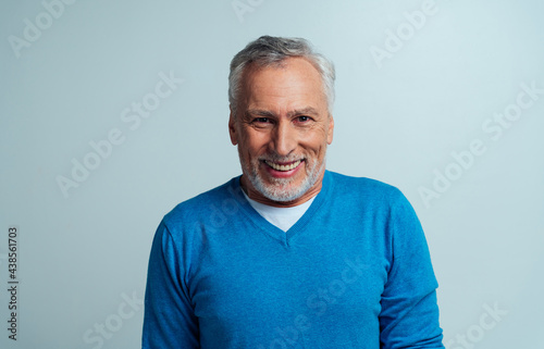 Handsome senior man isolated on grey background © oneinchpunch