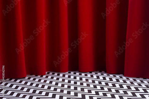 Theatre scene with red velvet curtain and black and white tile on floor. Stage for displaying product in twin peaks style. photo