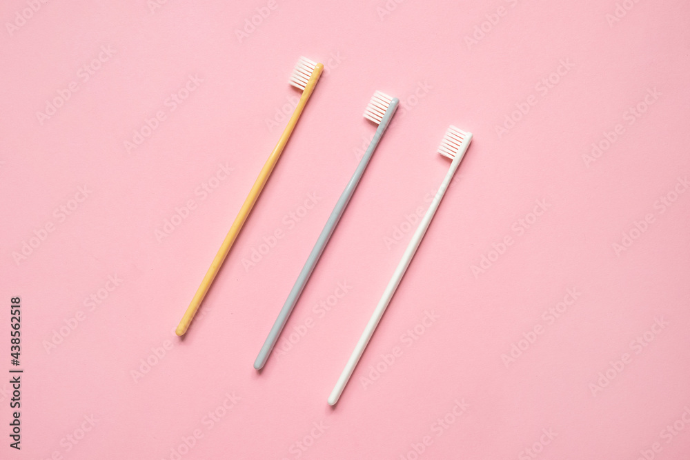 Pastel color toothbrushes on pink background .Simple composition for cleaning teeth and morning routine Pastel color toothbrushes on pink background .Simple composition for cleaning teeth and morning routine