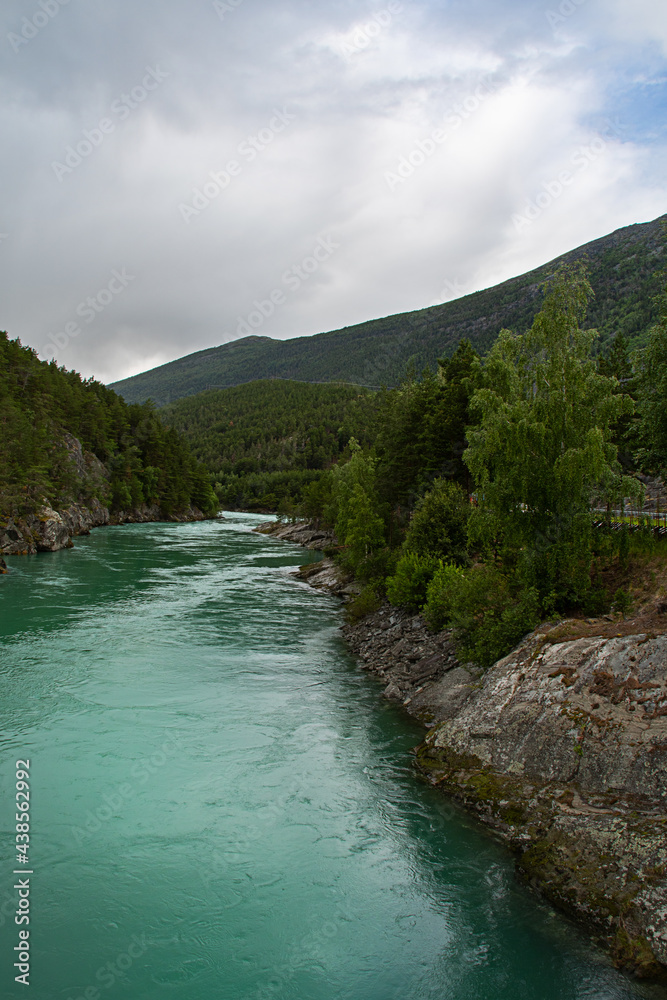 Mountain river in the mountains. Otta river, Norway. The turquoise color comes from algae in melted snow. Vertical photo. Copy space. The river is known for rafting.