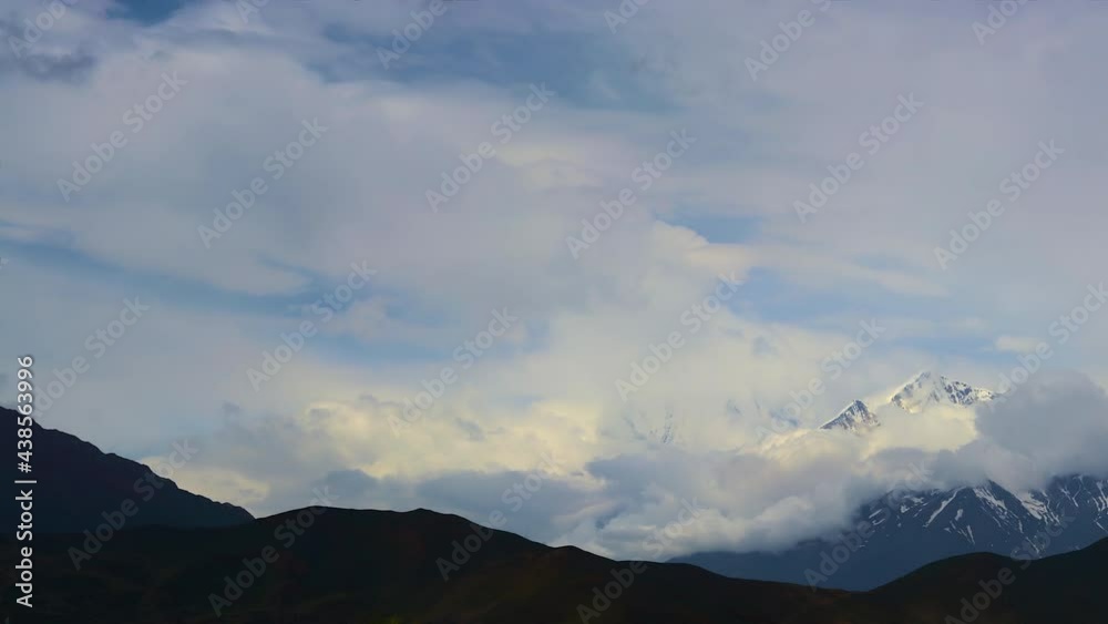 Timelapse Clouds swirl over a mountain valley, a snowy peak in the distance. Mustang, Nepal, Annapurna Timelapse Clouds swirl over a mountain valley, a snowy peak in the distance. Mustang, Nepal, Annapurna