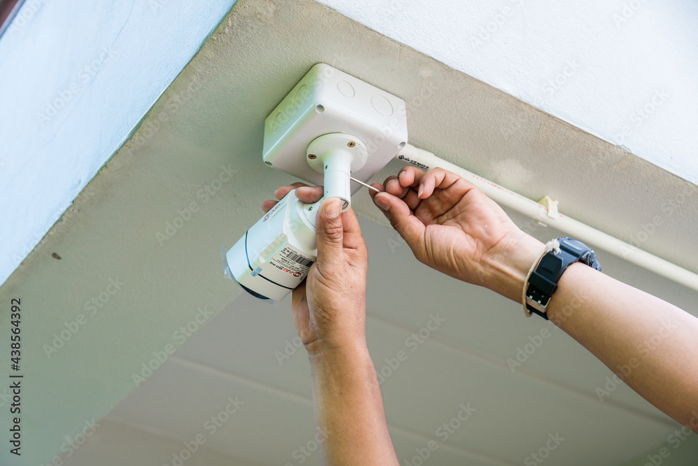 Fototapeta premium Technician installing wireless CCTV camera system on the building wall