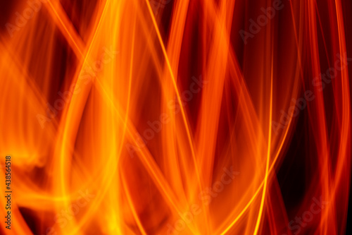 Light wave trail path, vibrant neon gold color in abstract swirls on a black background