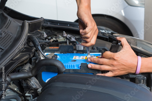 Male mechanic changing car battery ,Car service ,fitting a car battery with wrench